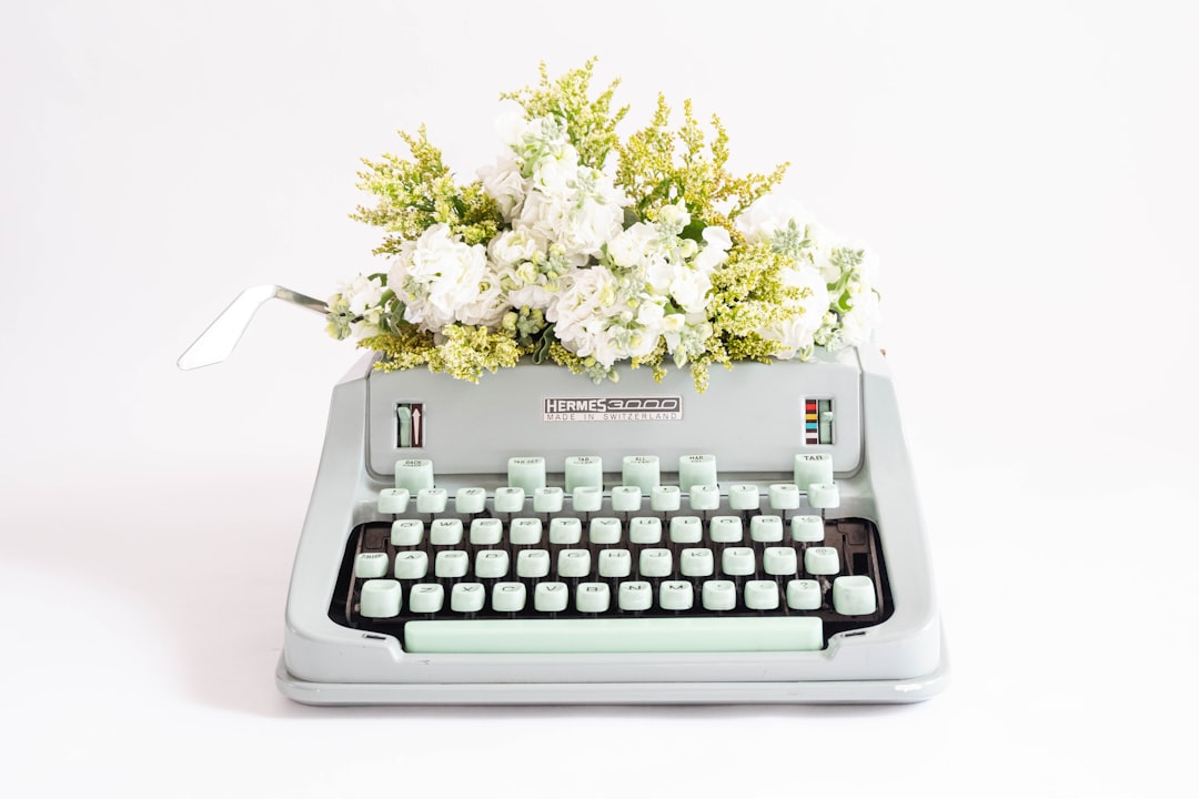 a typewriter with a bunch of flowers on top of it