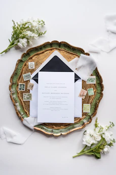 Elegant wedding invitations and gift boxes arranged on a wooden table.