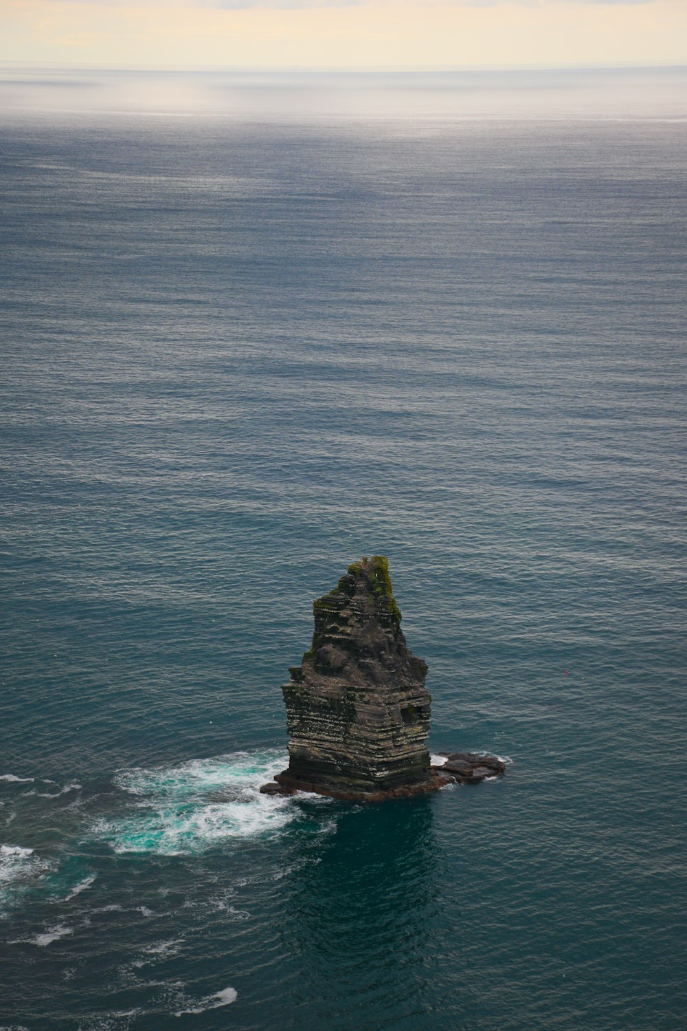 a large rock sticking out of the ocean