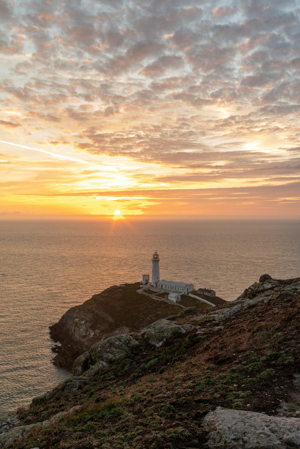 Un phare assis au sommet d’une falaise près de l’océan