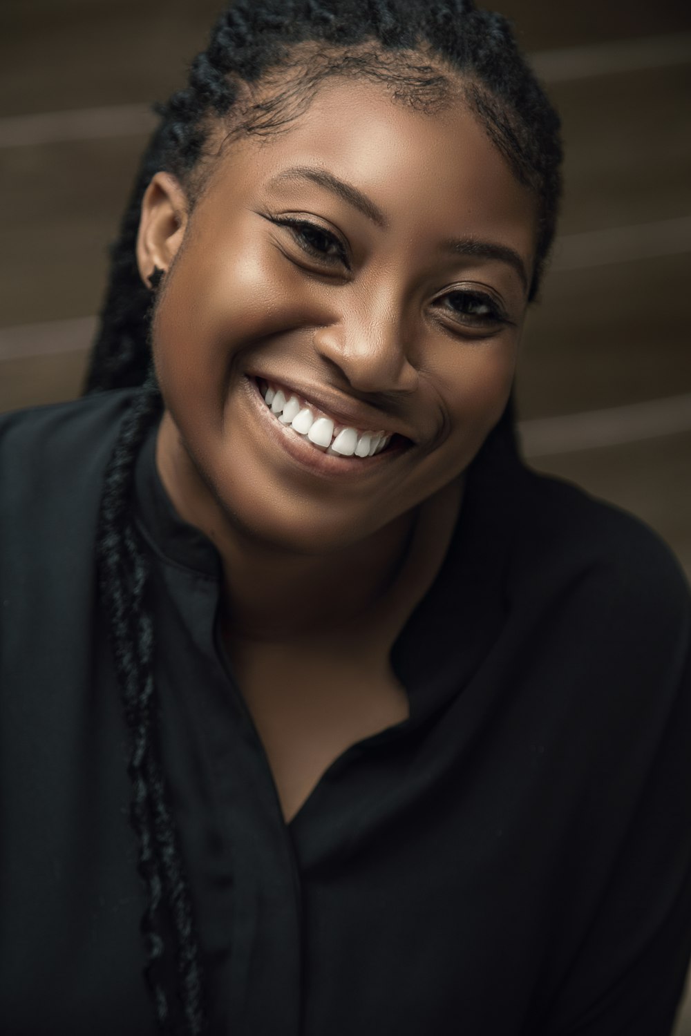 a smiling woman with braids and a black shirt