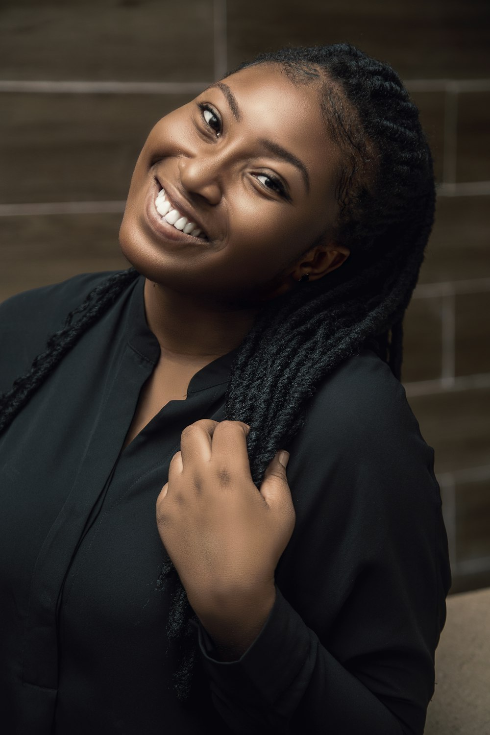 a smiling woman with braids on her hair