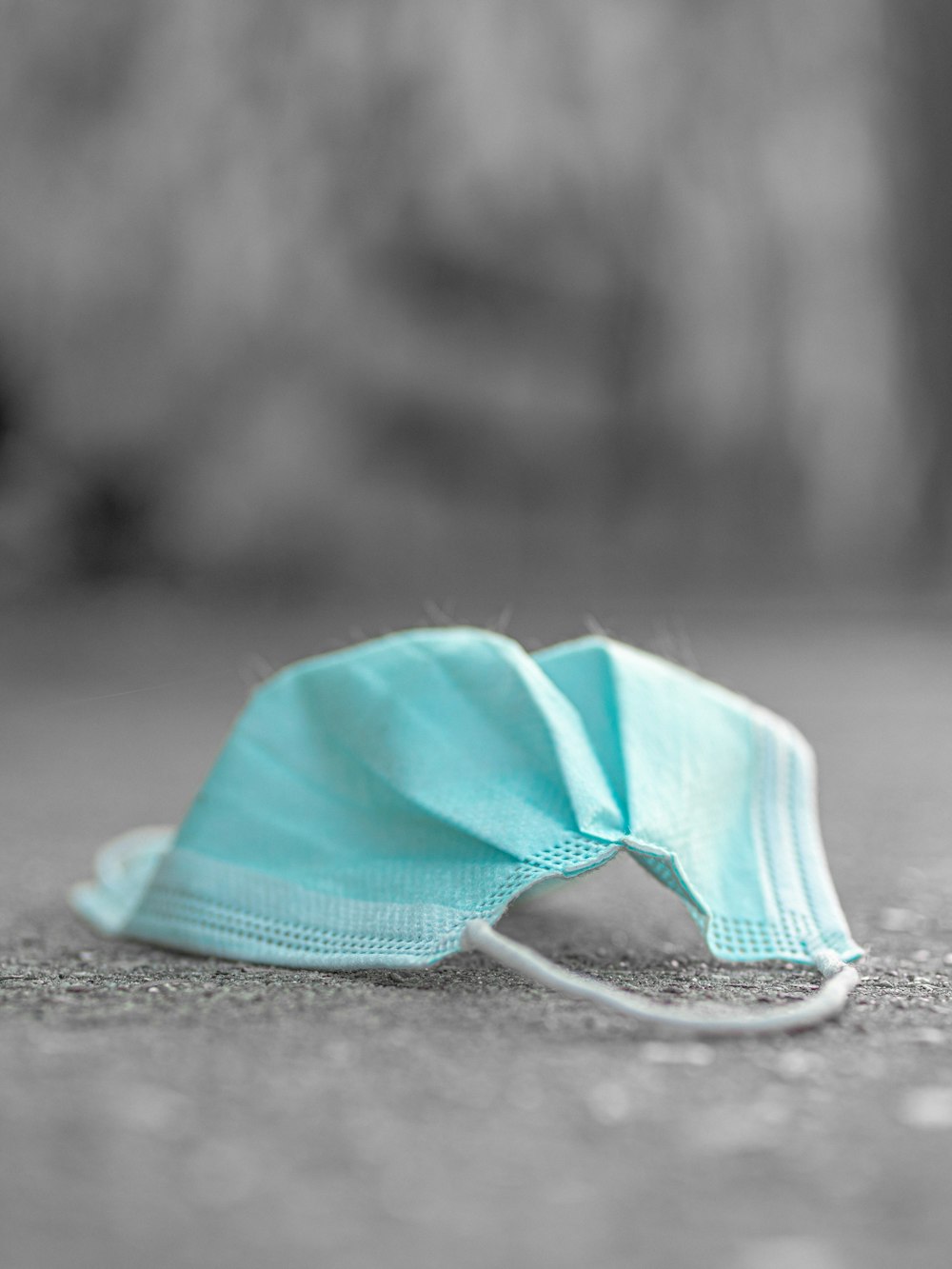 a blue face mask laying on the ground