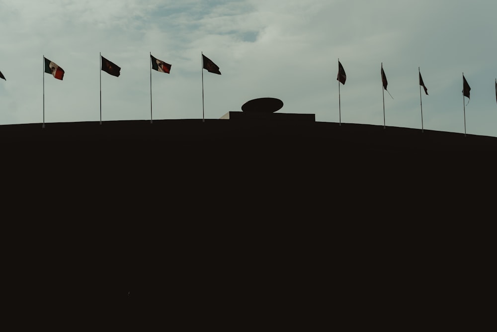 Un groupe de drapeaux flottant au sommet d’une colline