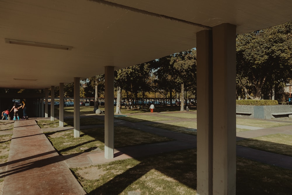 a group of people walking down a sidewalk next to a park