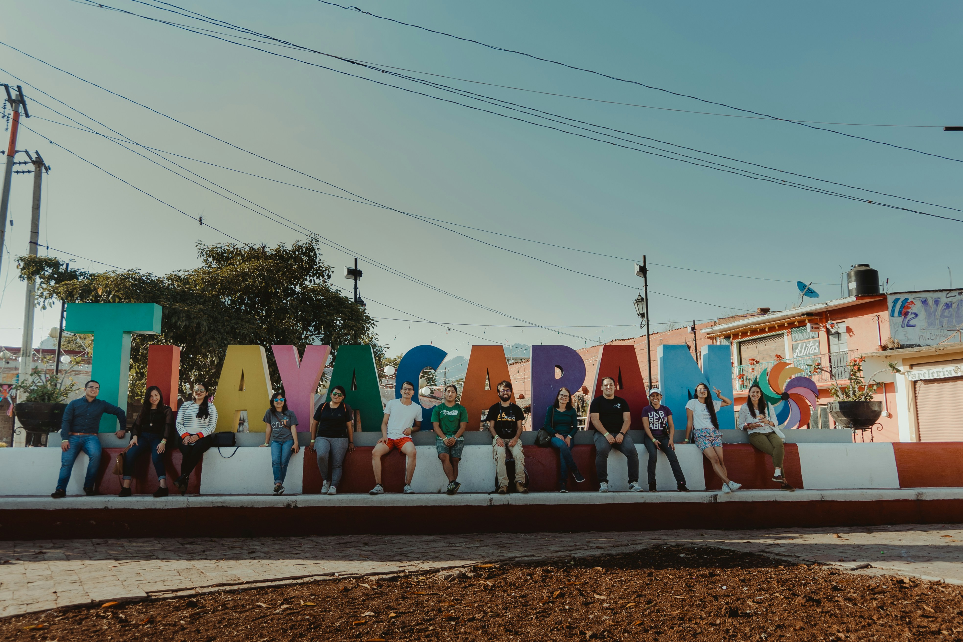 a group of people sitting in front of a large sign