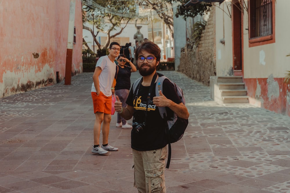 Un homme avec un sac à dos se tient dans la rue