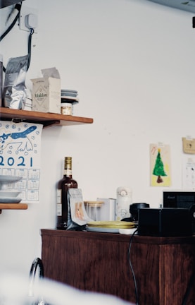 A cozy kitchen corner with wooden shelves displaying vintage kitchen tools and fresh herbs.