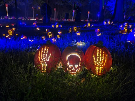 Festival crowd enjoying a spooky night with glowing pumpkins and eerie lights.