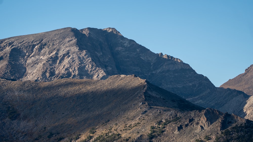 Una cadena montañosa con un cielo azul claro en el fondo
