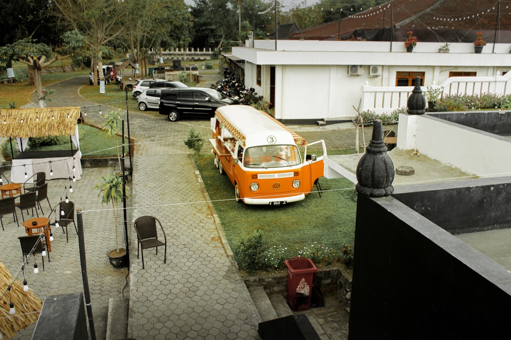 an orange and white bus parked in front of a building