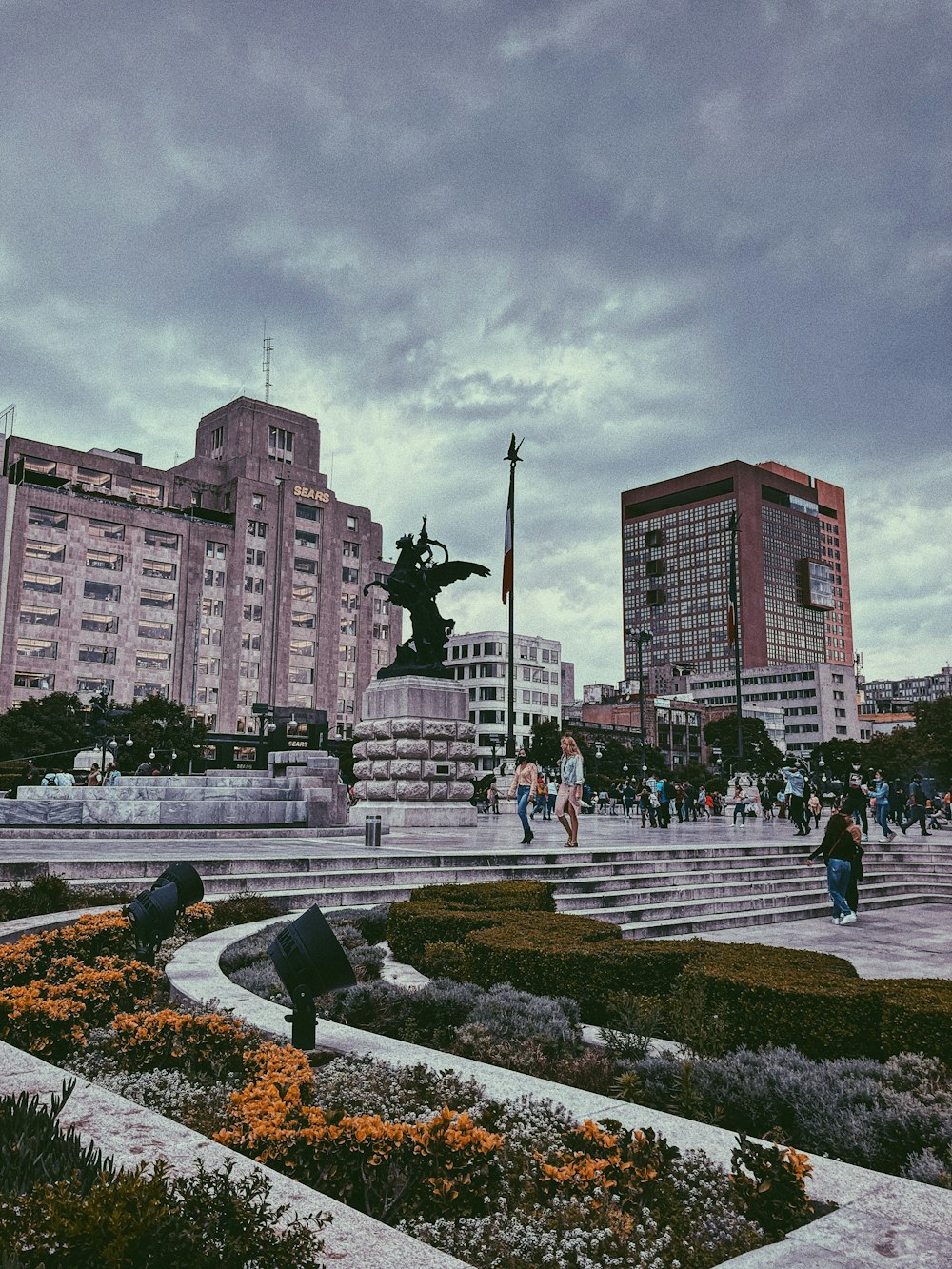 a group of people walking around a city square