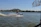 A man speeding across the water on a jet ski with splashes and a bright sky overhead