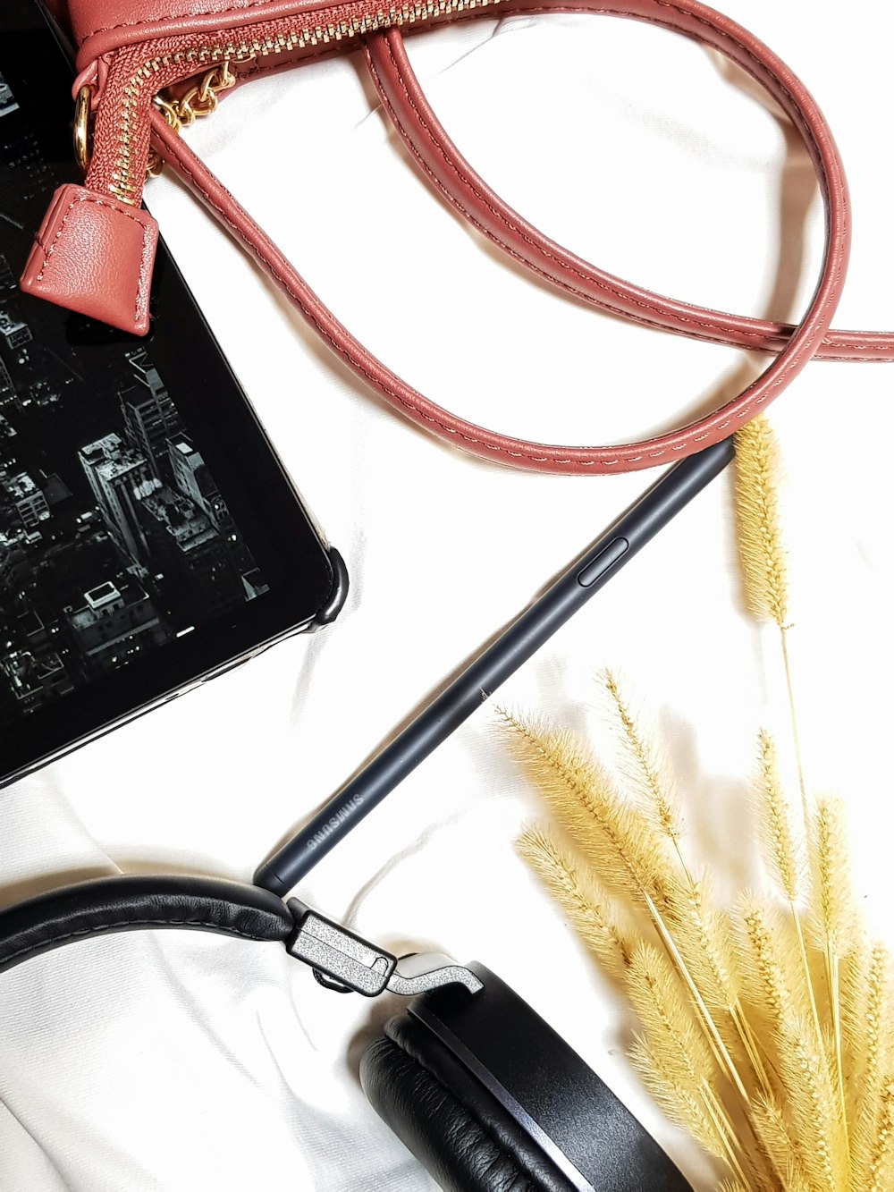 a cell phone, headphones, and a purse on a table