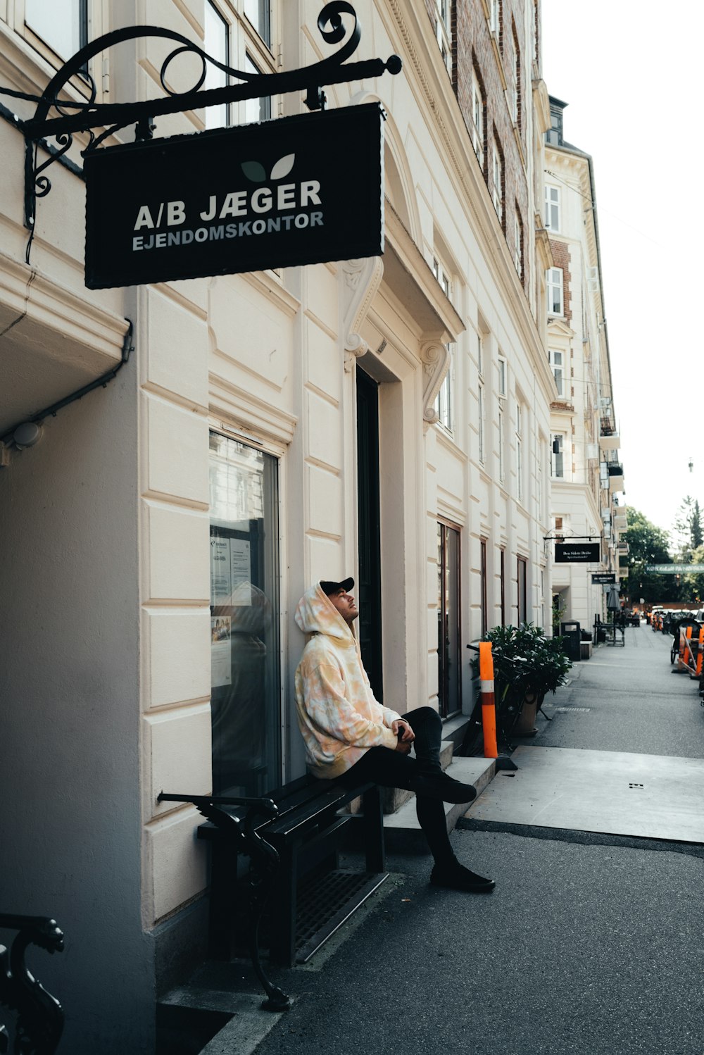 a man sitting on a bench in front of a building