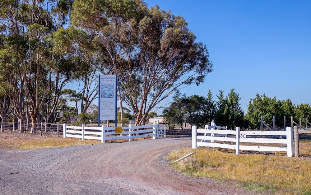 a road with a white fence and a sign