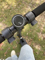 Close-up of a hand gripping the handlebar of a modern electric scooter with digital display.