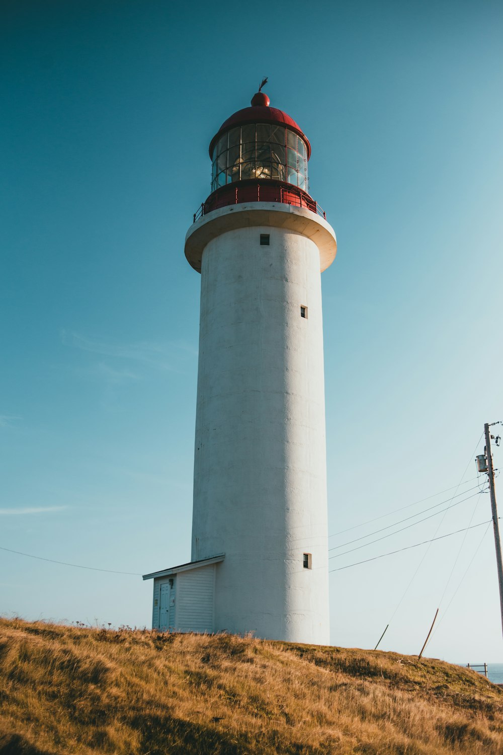 a white and red light house on a hill