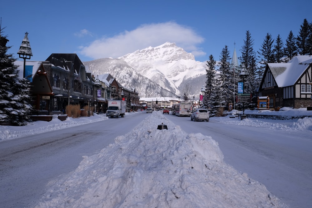 a snow covered street with a mountain in the background