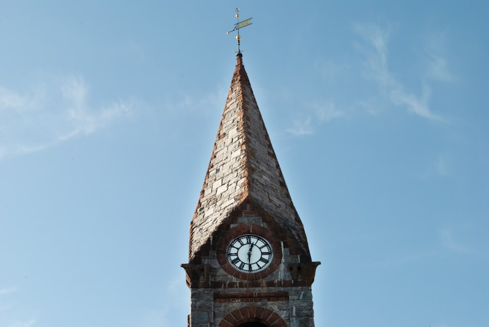 a clock tower with a cross on top of it