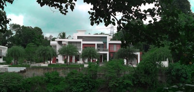 Modern white house with large windows and a garden at sunset.