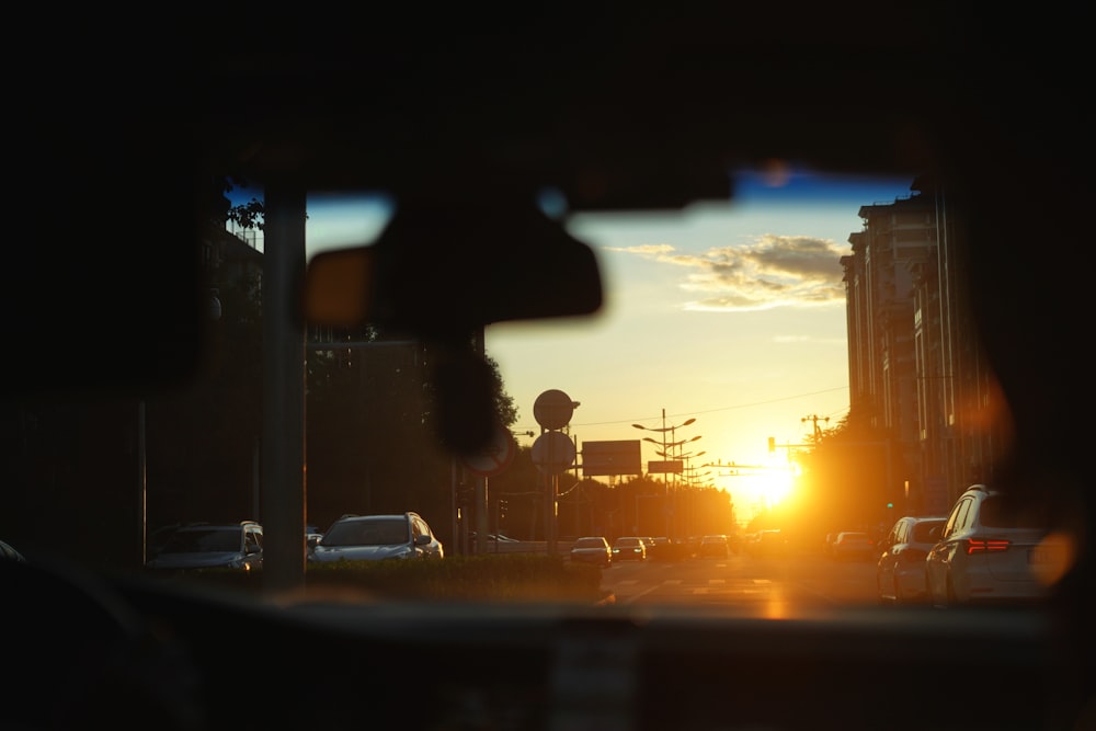 the sun is setting over a busy city street