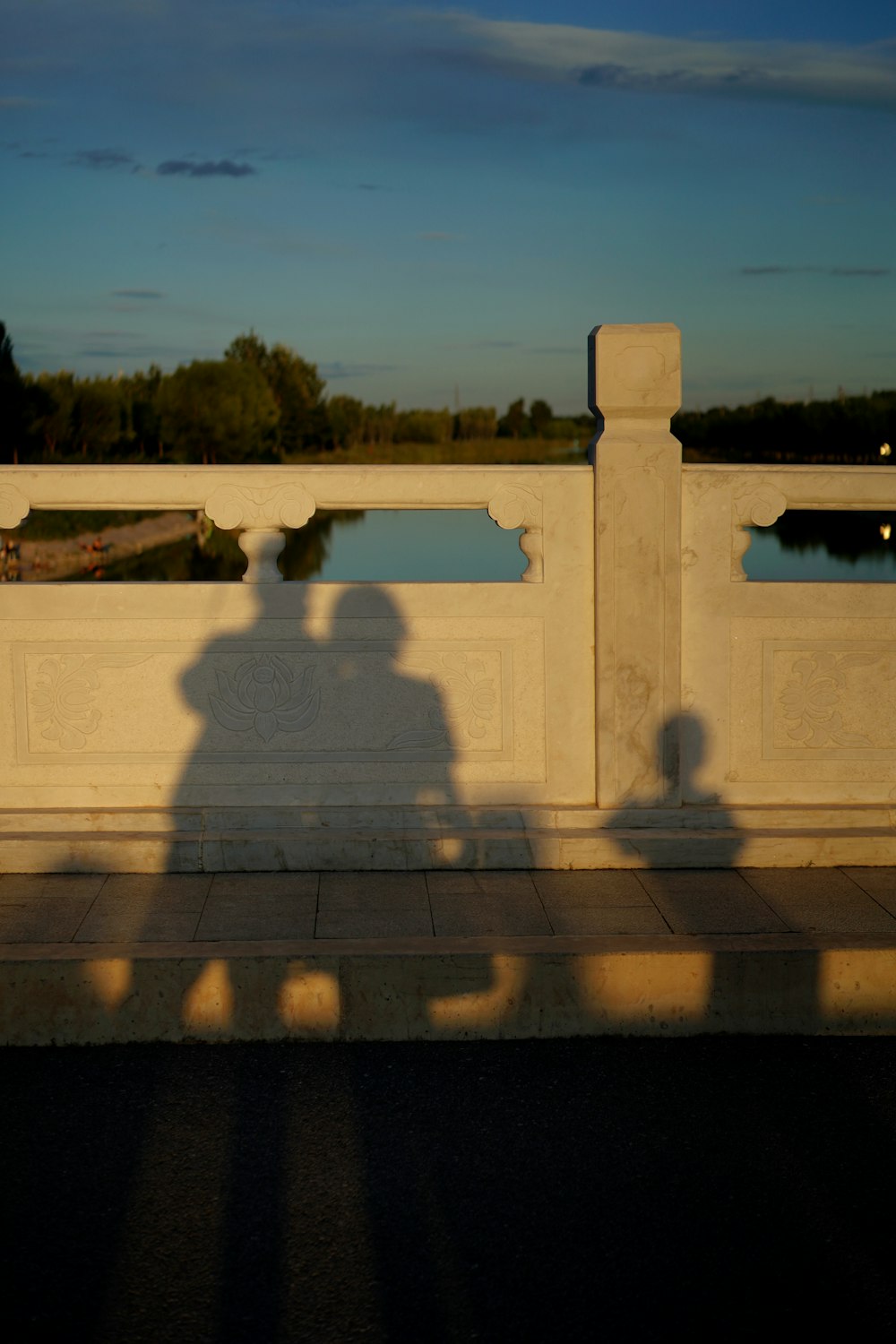 a shadow of two people on a bridge