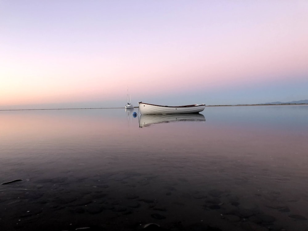 a small boat sitting on top of a large body of water