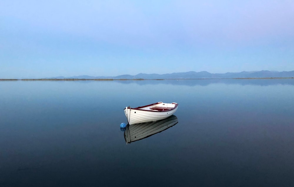 a small boat floating on top of a large body of water