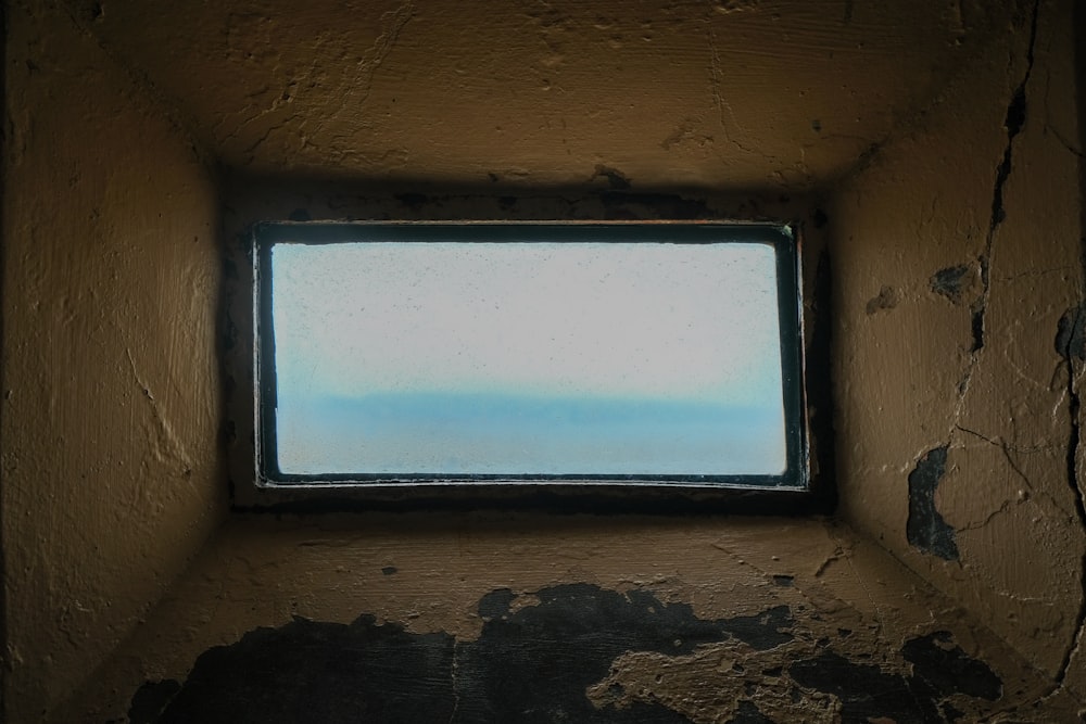 a window in a wall with a sky view