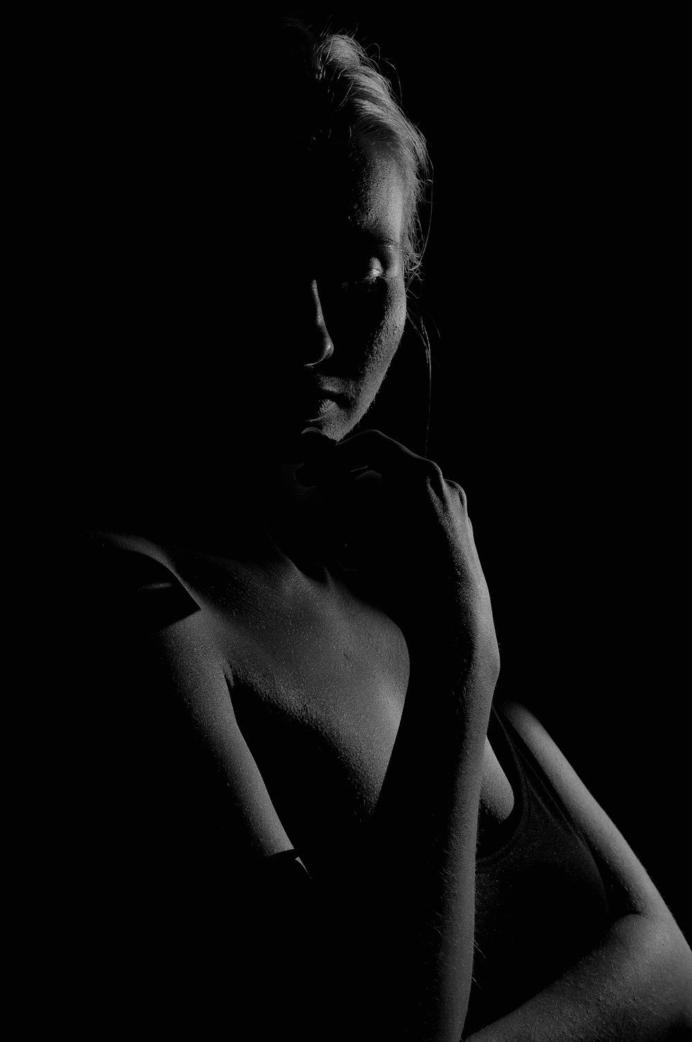 a black and white photo of a woman in the dark