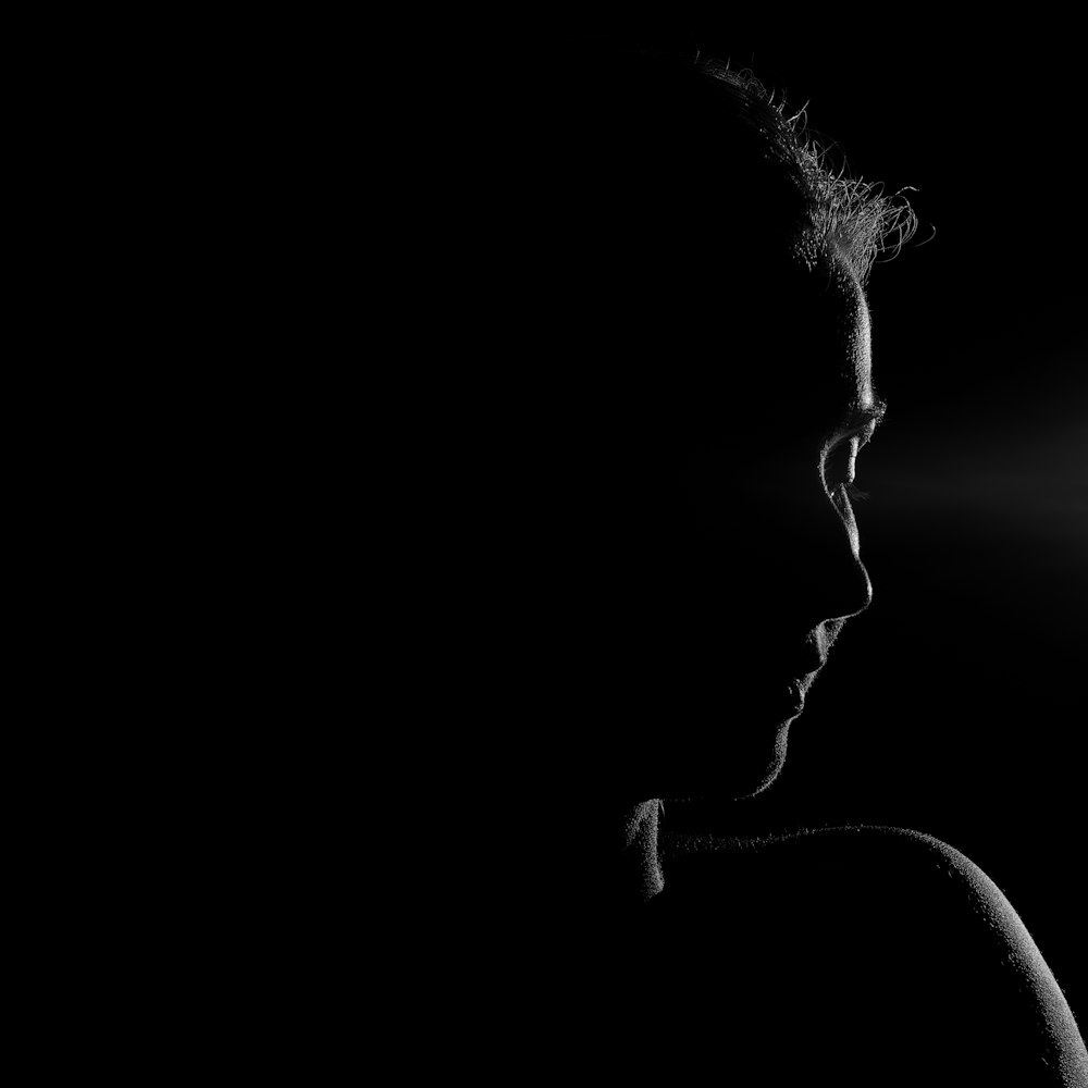 a woman in the dark with a light shining on her face