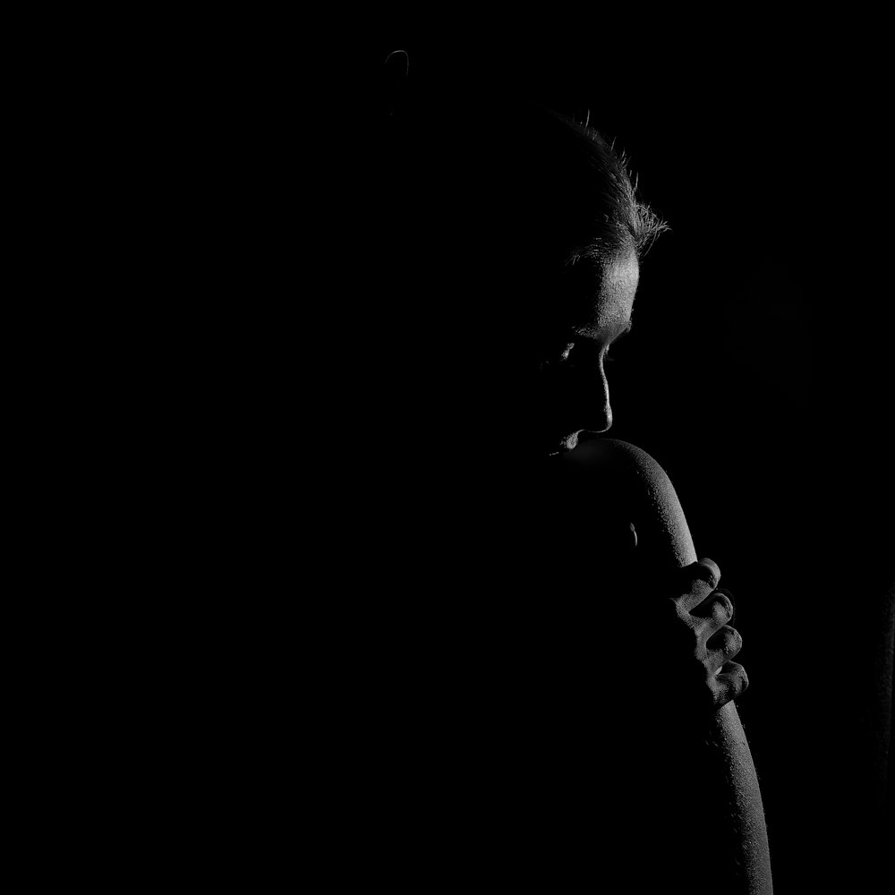 a black and white photo of a woman in the dark