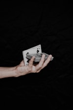 a person holding playing cards in their hand