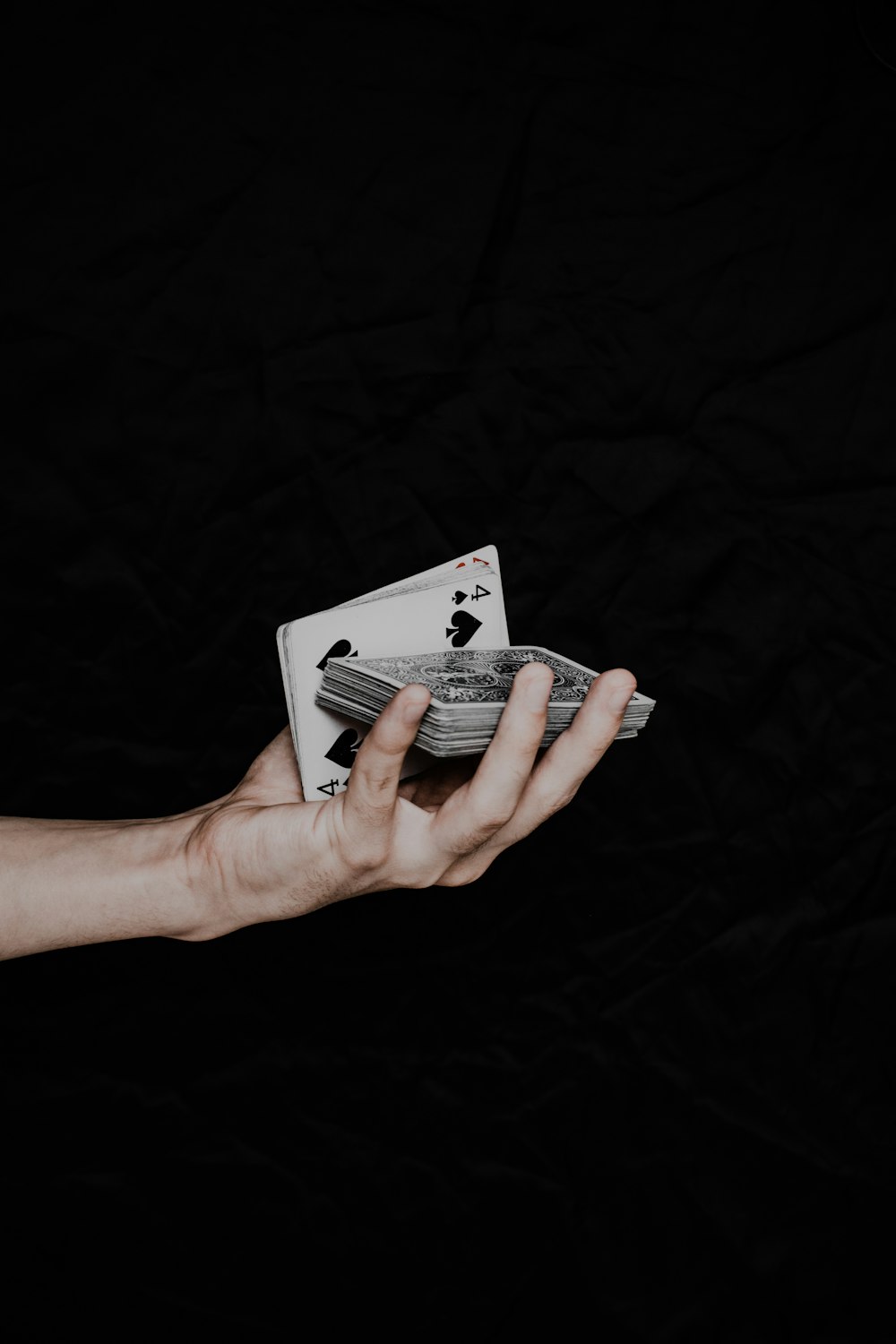 a person holding playing cards in their hand