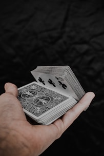 a person holding a playing card in their hand