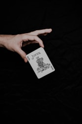 a person holding a playing card in their hand