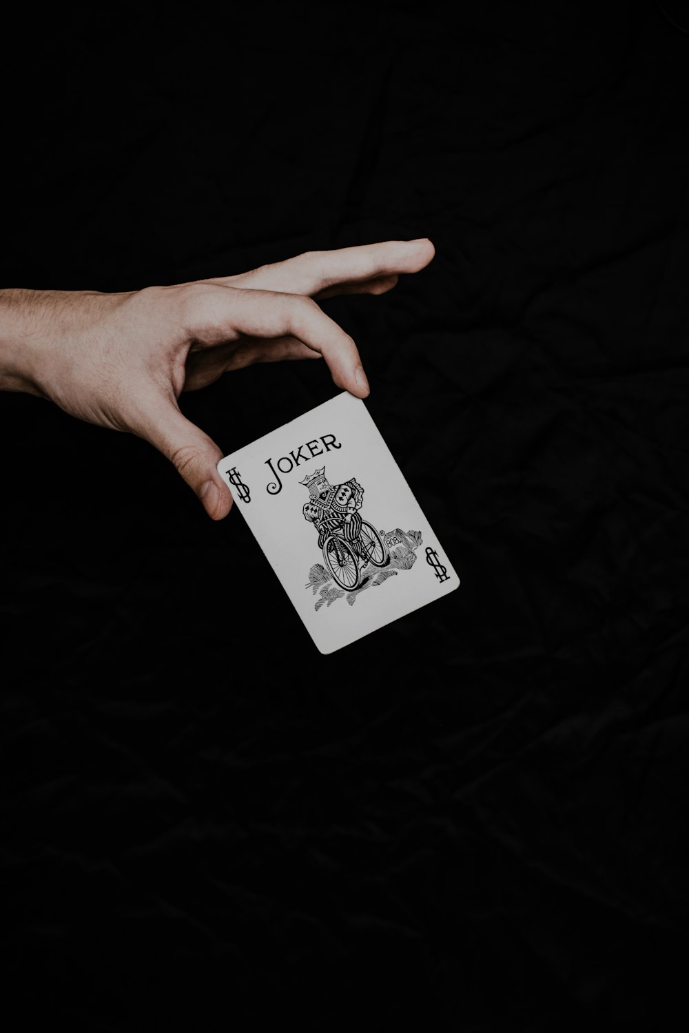 a person holding a playing card in their hand