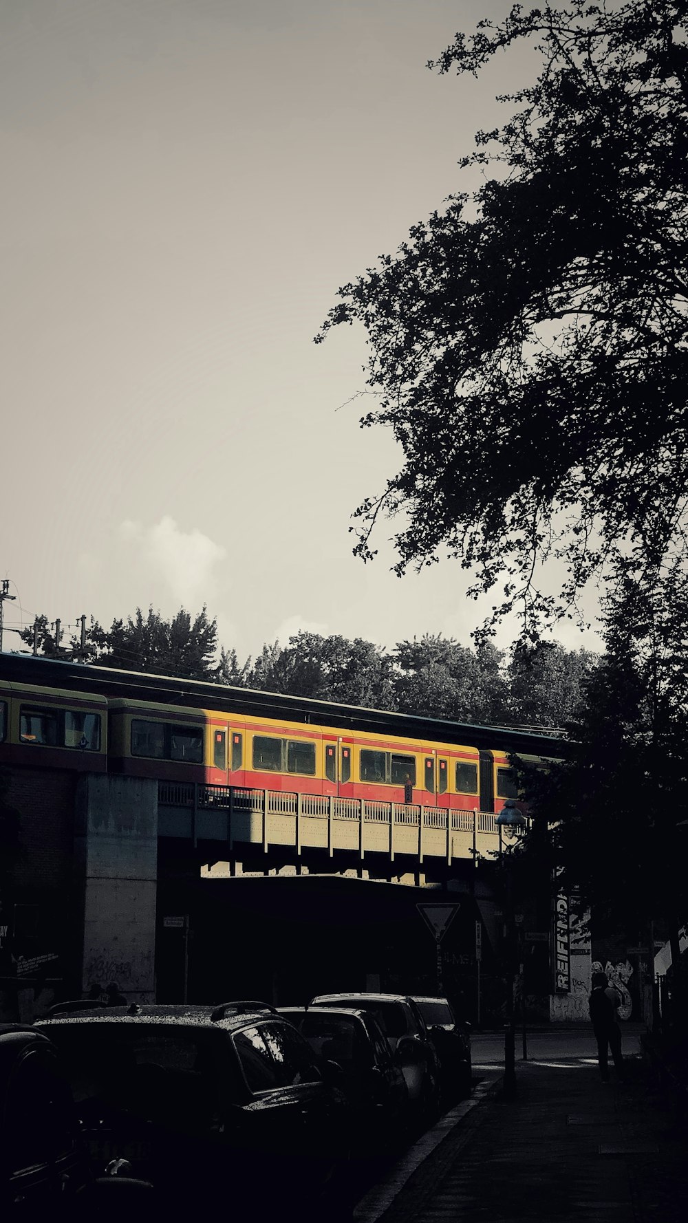 a yellow and red train traveling over a bridge