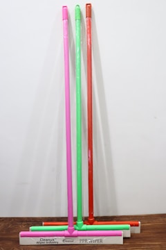 Set of different sized squeegees arranged neatly on a wooden table.