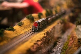 Close-up of a detailed 1/64 scale train diorama with miniature trees and tracks