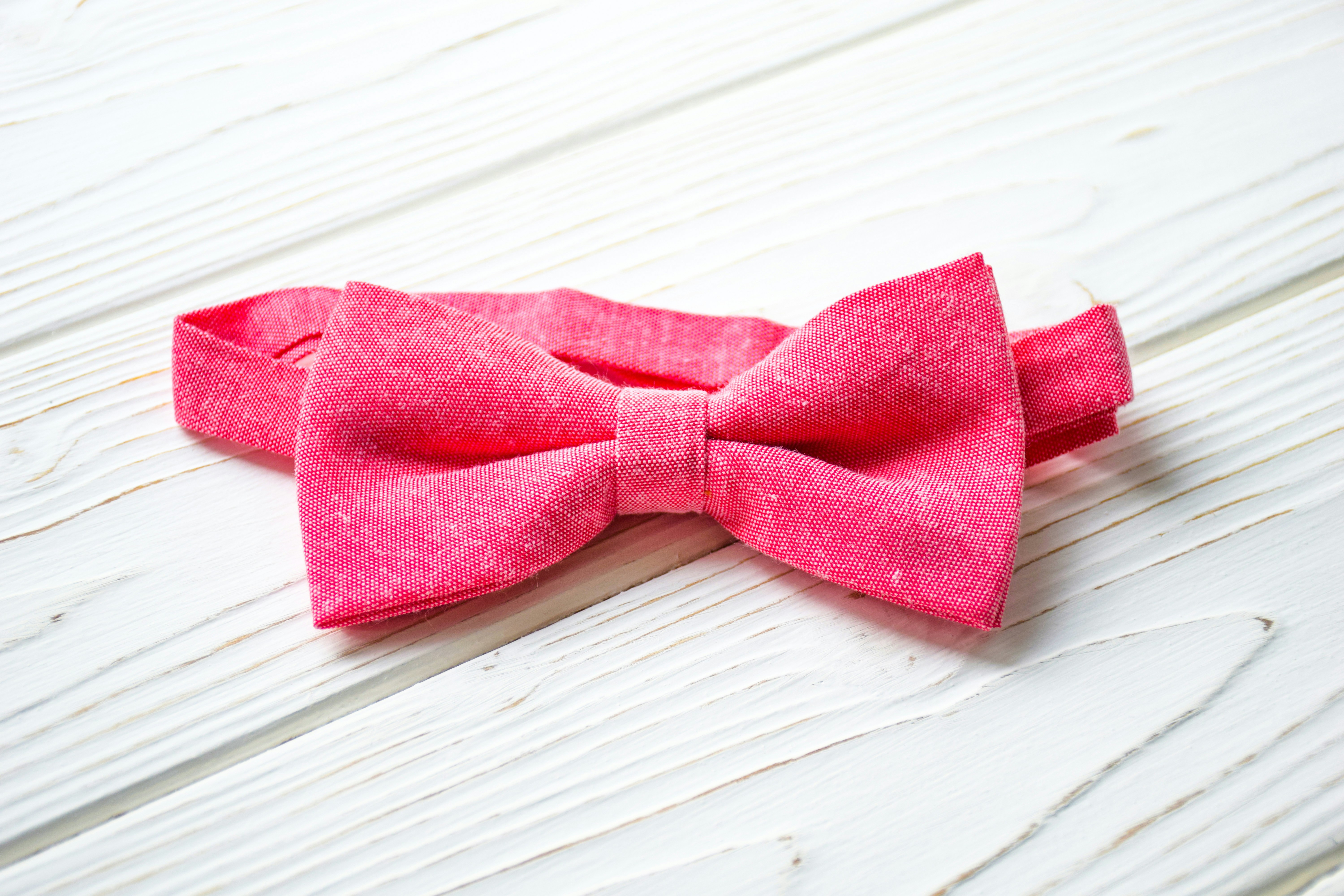 a pink bow tie sitting on top of a white table
