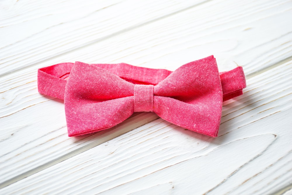 a pink bow tie sitting on top of a white table
