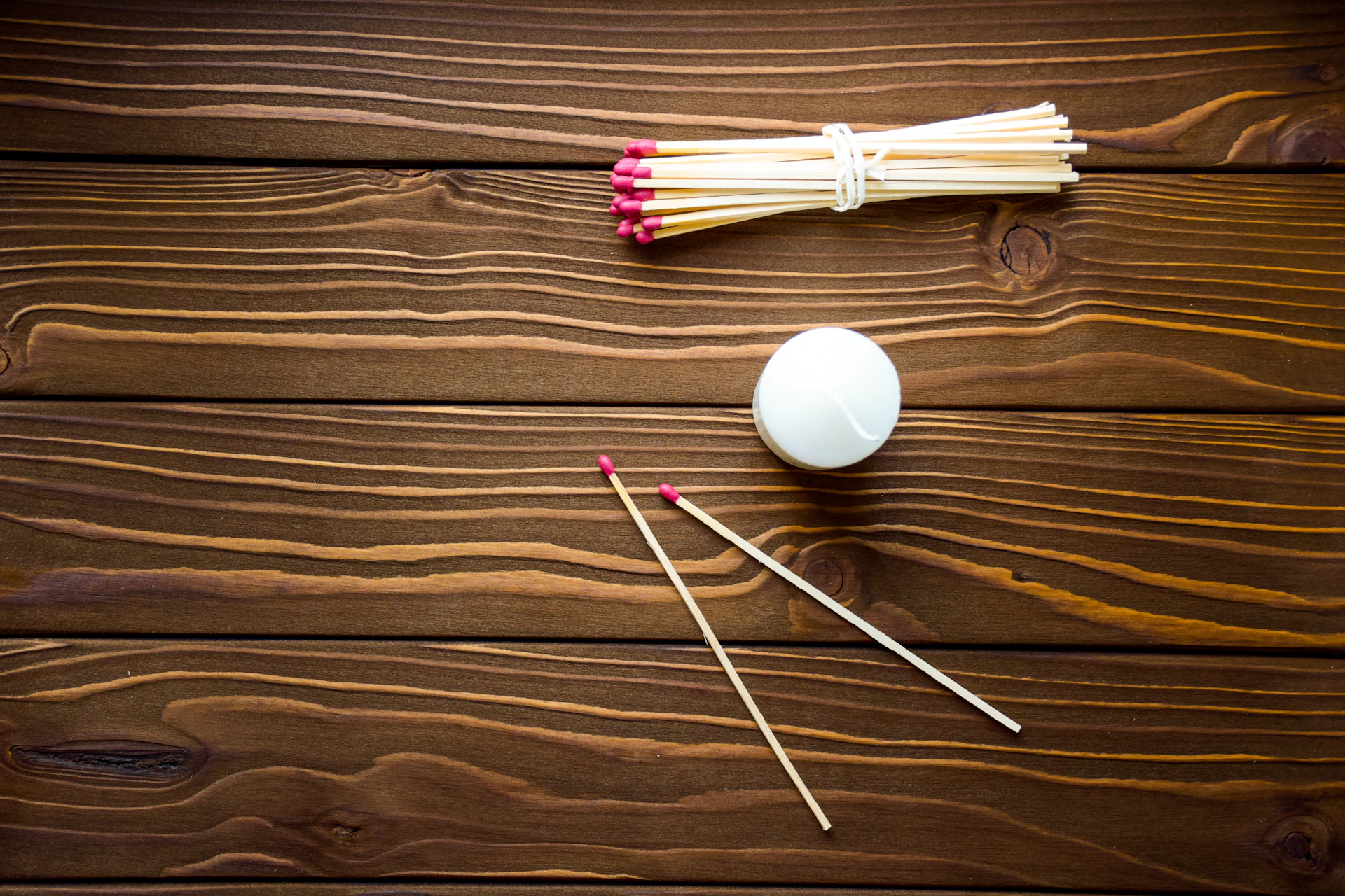 a group of matches and a white ball on a wooden table