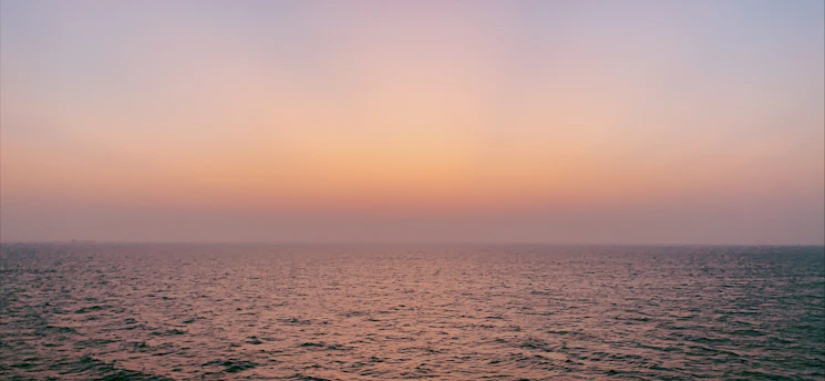 A serene ocean horizon blending shades of blue and white under a soft morning sky.