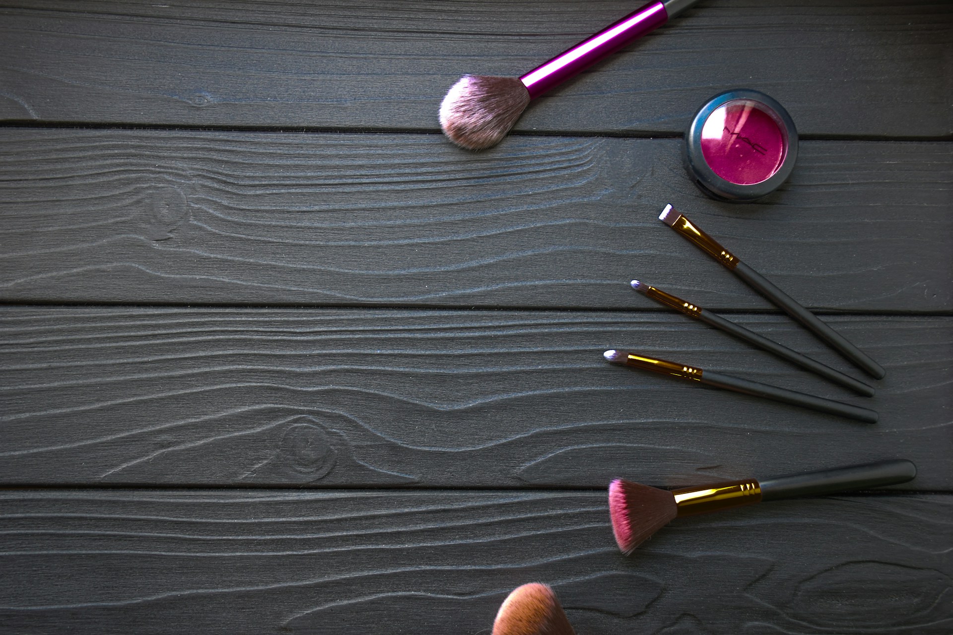 a person's hand is holding a brush and a set of makeup brushes