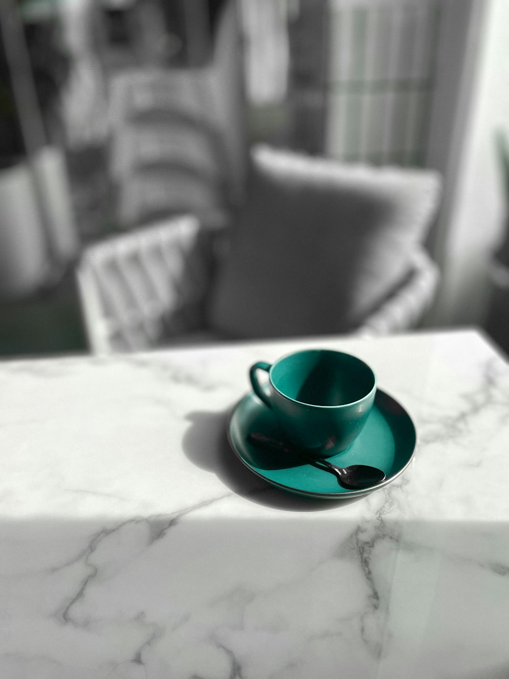 a cup and saucer sitting on a marble table