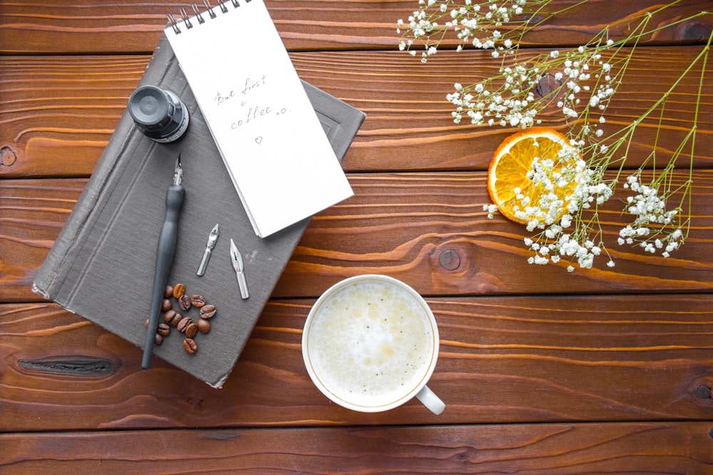 a cup of coffee and a notepad on a wooden table