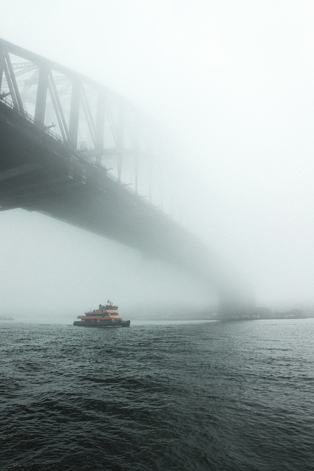 a boat in the water under a bridge