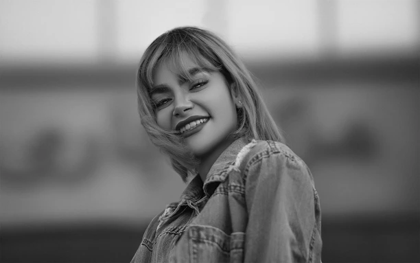 A softly lit portrait of a smiling customer wearing the kinetic moto jacket outdoors.